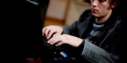 Image of potential cybercriminal working at computer