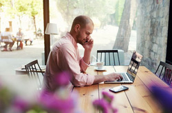Image of a man sitting at a laptop computer
